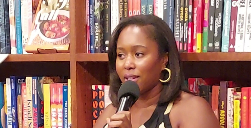 Kiano Moju in front of bookcases at Bold Fork Books.