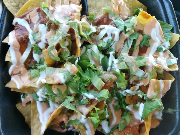 Loaded nachos with vegan cheese from Houston Sauce Co, a Black owned vegan food truck