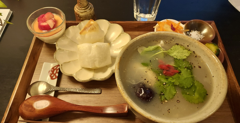 mute cafe tokyo review. Samgyetang chicken soup set with mochi, a small dessert with fresh strawberries and pickled vegetables on a small wooden tray.
