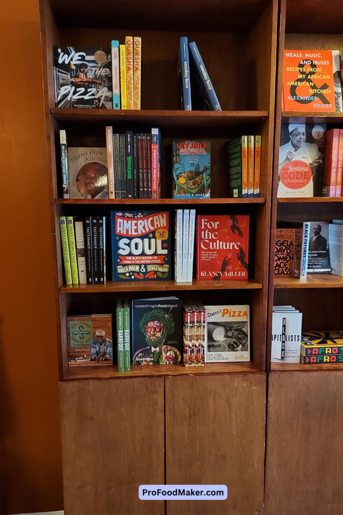 Bookcase for cookbooks inside BEM books & more. Some of the books pictured: American Soul by Anela Malik and For the Culture by Klancy Miller