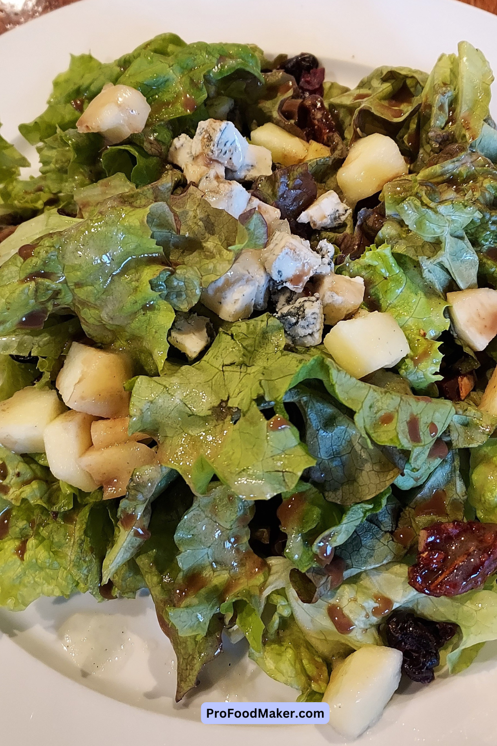 Apple and bleu cheese salad on a white plate