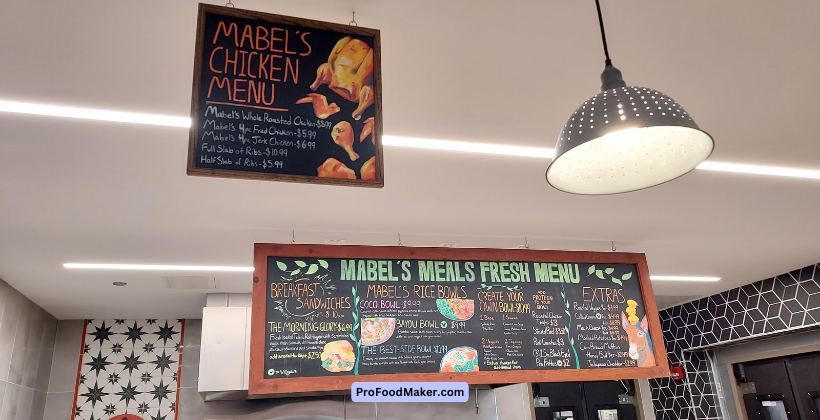 Forty Acres Fresh Market menu on a chalkboard framed with wood. Breakfast sandwiches, Mabel's Rice Bowls and more are listed with prices.